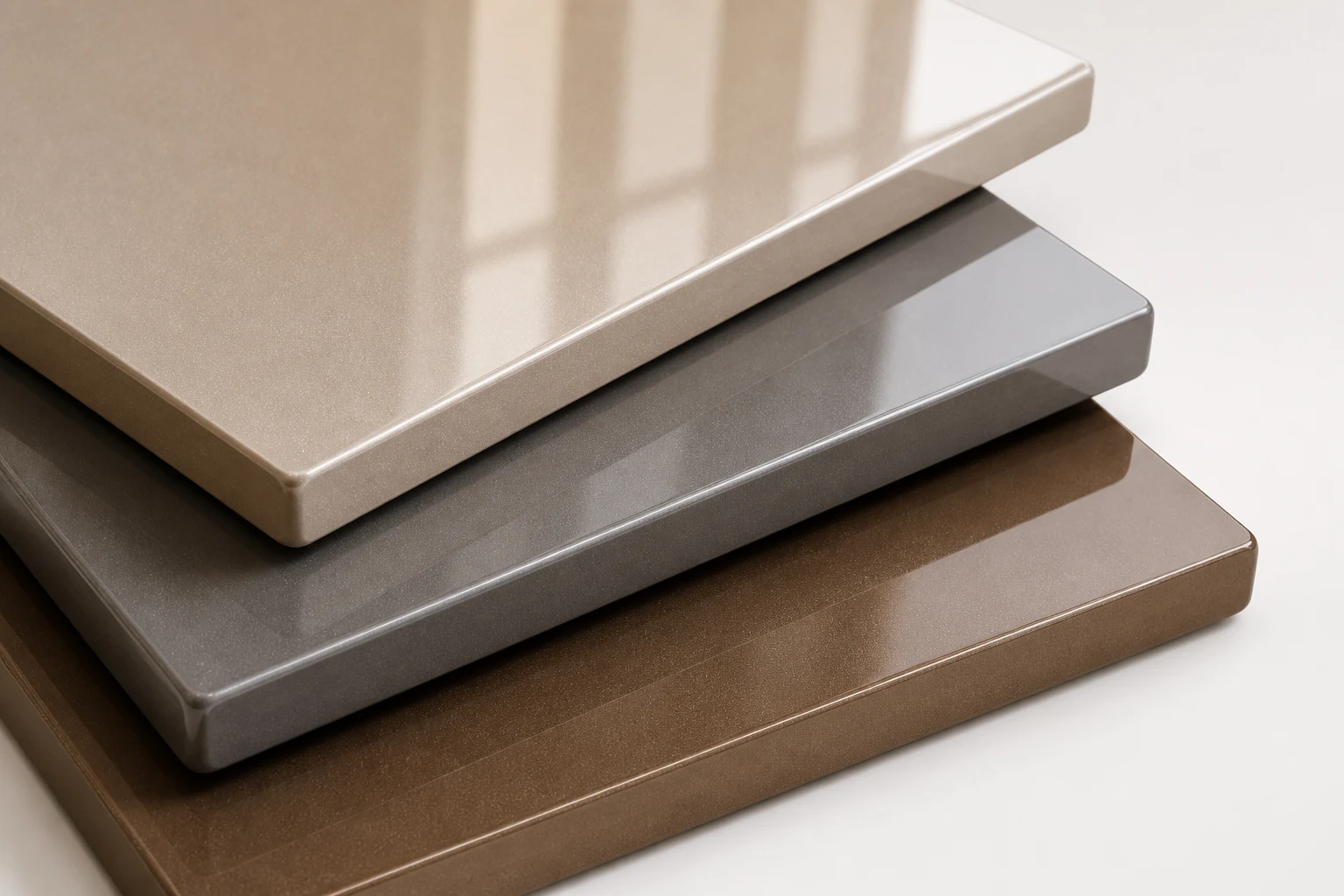 Layered high-gloss metallic panel samples in champagne, pewter and bronze